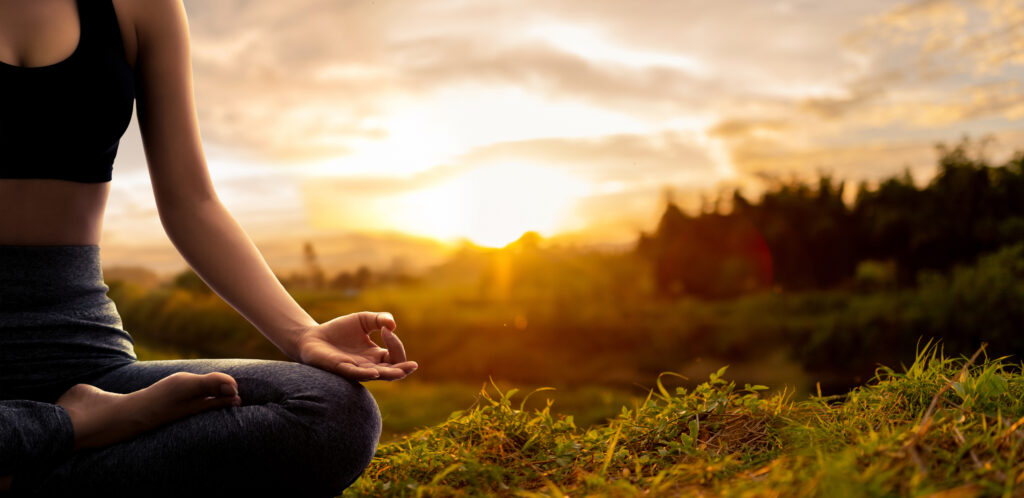 Young woman practicing yoga in the nature.female happiness. Landscape background